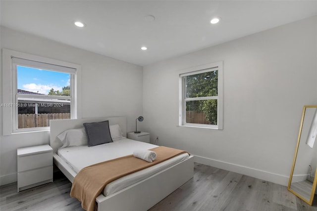 bedroom featuring light hardwood / wood-style floors and multiple windows