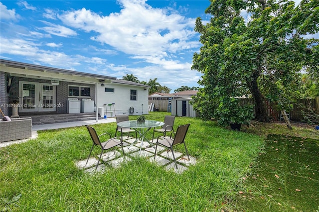 view of yard featuring a storage unit, french doors, and a patio area