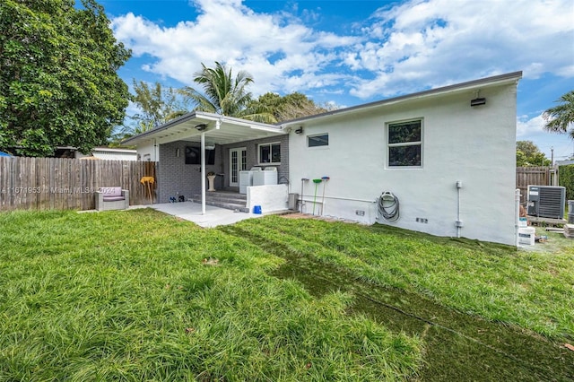 back of house featuring a yard, central AC, and a patio