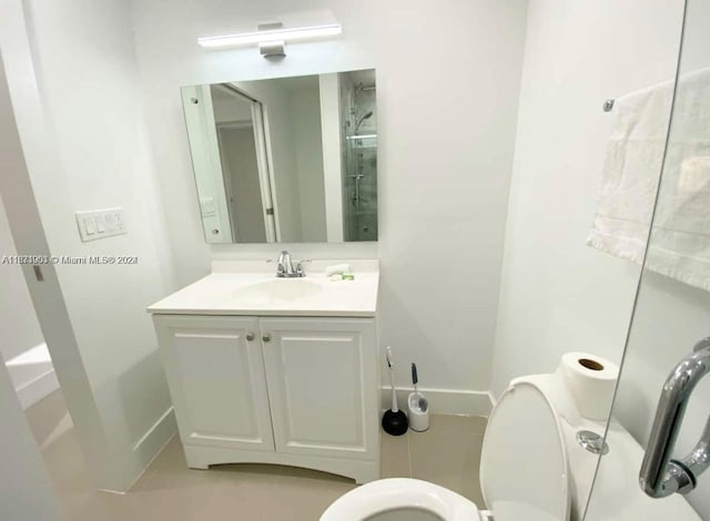 bathroom with walk in shower, vanity, and toilet