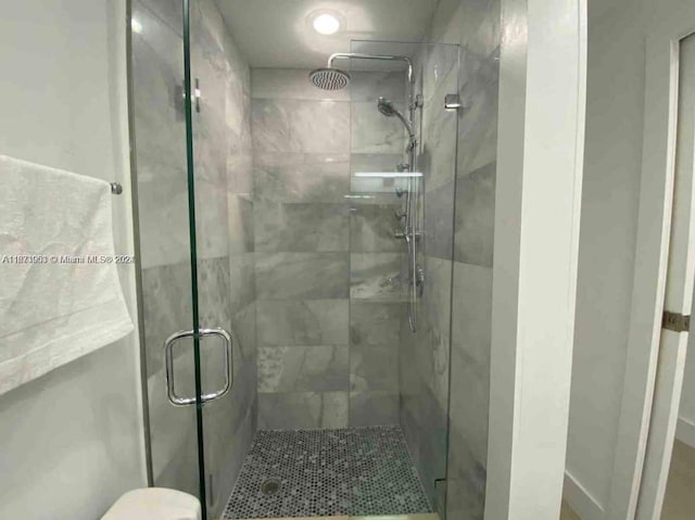 bathroom with toilet and a shower with shower door