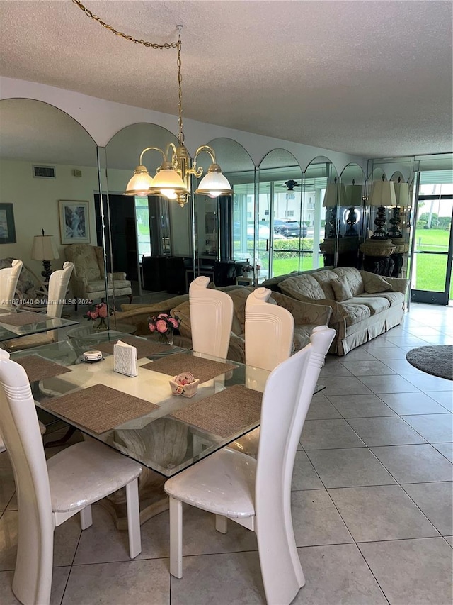 dining space with a notable chandelier, a textured ceiling, and tile patterned floors