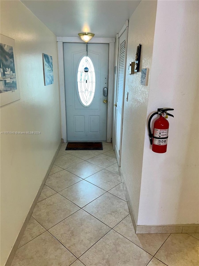 doorway to outside with light tile patterned flooring