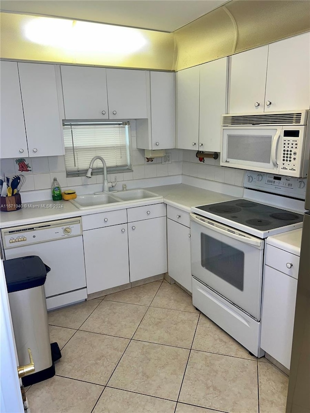 kitchen featuring light tile patterned floors, sink, white appliances, and white cabinetry