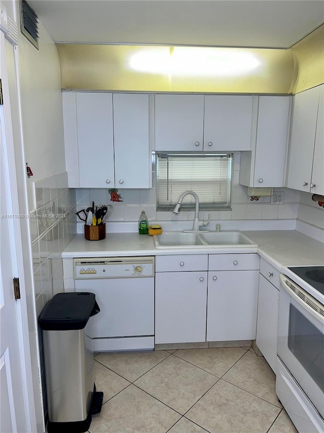 kitchen with light tile patterned floors, sink, white appliances, and white cabinetry