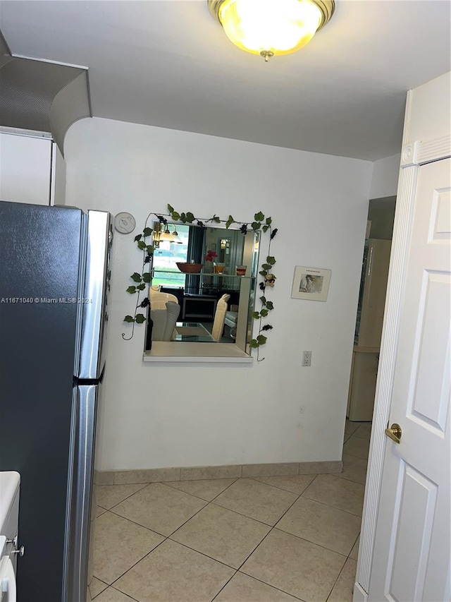 kitchen featuring light tile patterned flooring and stainless steel refrigerator