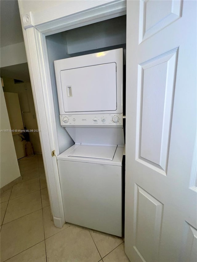 washroom featuring stacked washer / dryer and light tile patterned floors