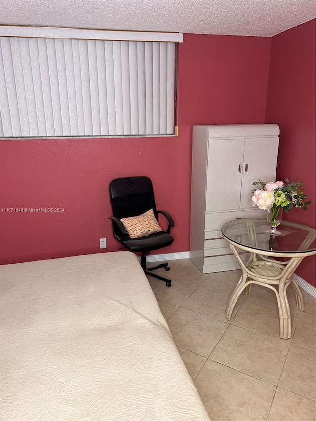 tiled bedroom featuring a textured ceiling