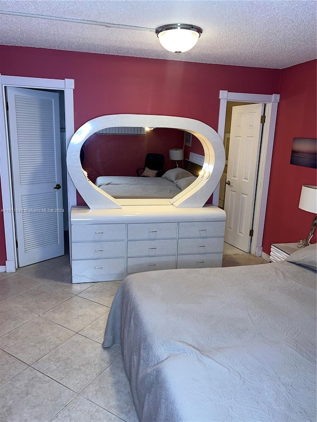 bedroom featuring a textured ceiling and light tile patterned flooring