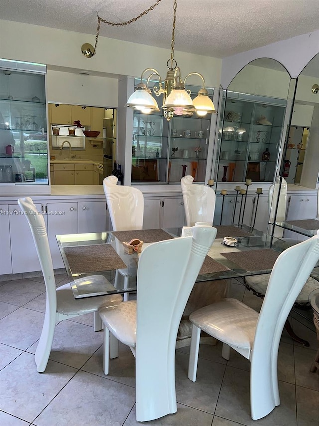 dining room featuring a textured ceiling, light tile patterned floors, and a notable chandelier