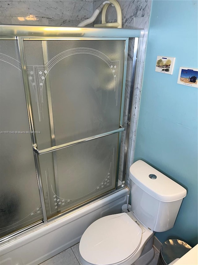 bathroom featuring tile patterned flooring, shower / bath combination with glass door, and toilet