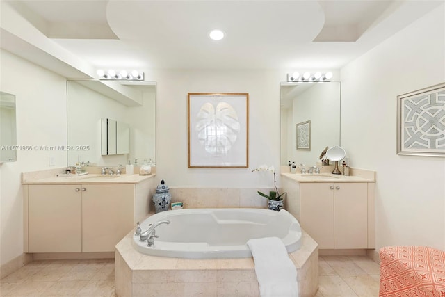 bathroom featuring vanity, tile patterned flooring, and tiled bath