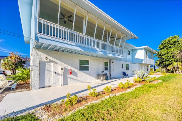 back of house featuring a balcony, a yard, a patio area, and ceiling fan