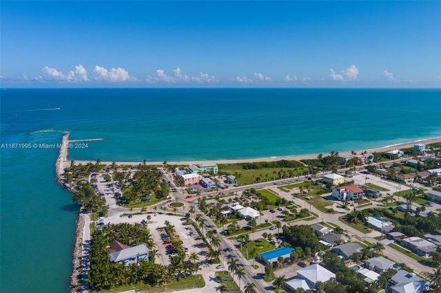 drone / aerial view with a water view and a beach view