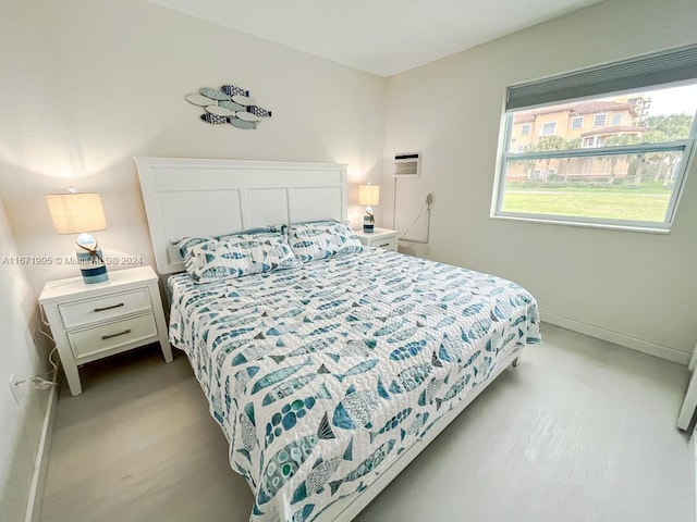 bedroom with a wall mounted air conditioner and light colored carpet