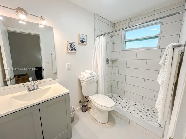 bathroom with toilet, a shower with curtain, vanity, and tile patterned floors