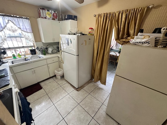 kitchen featuring light tile patterned flooring, white cabinetry, white refrigerator, ceiling fan, and sink