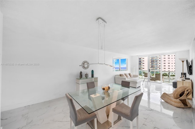 dining space featuring expansive windows and marble finish floor