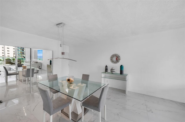 dining space featuring marble finish floor and a textured ceiling