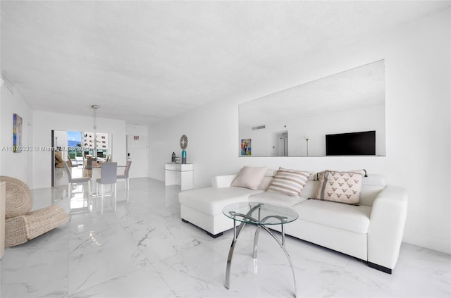 living area with a textured ceiling, marble finish floor, and visible vents