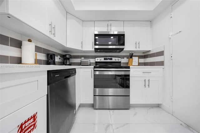 kitchen featuring marble finish floor, white cabinetry, appliances with stainless steel finishes, and light countertops