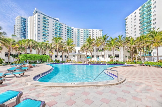 community pool with a view of city and a patio area