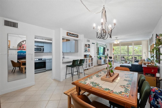 dining room with ceiling fan, sink, light tile patterned floors, and a textured ceiling