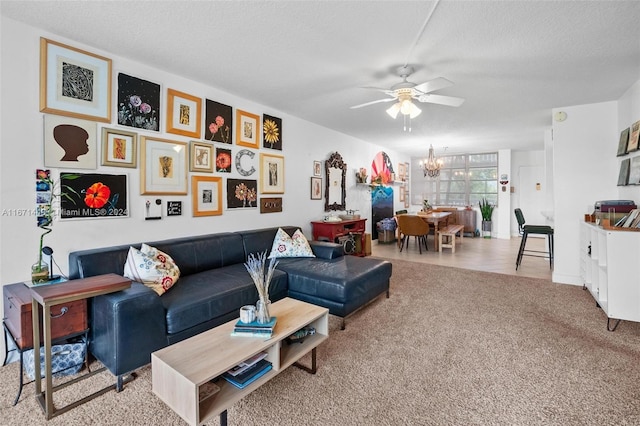 living room featuring ceiling fan with notable chandelier, a textured ceiling, and light colored carpet