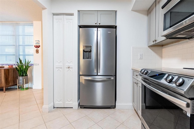 kitchen with decorative backsplash, appliances with stainless steel finishes, gray cabinets, and light tile patterned floors