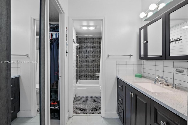 bathroom with tile patterned floors, vanity, and tiled shower / bath combo