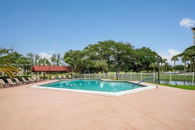 view of swimming pool featuring a water view and a patio