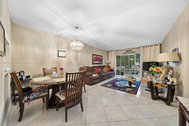 tiled dining space featuring a chandelier and a textured ceiling