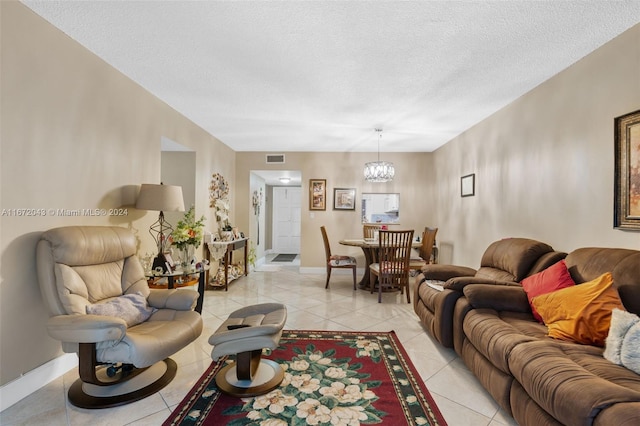 living room with a chandelier, a textured ceiling, and light tile patterned floors