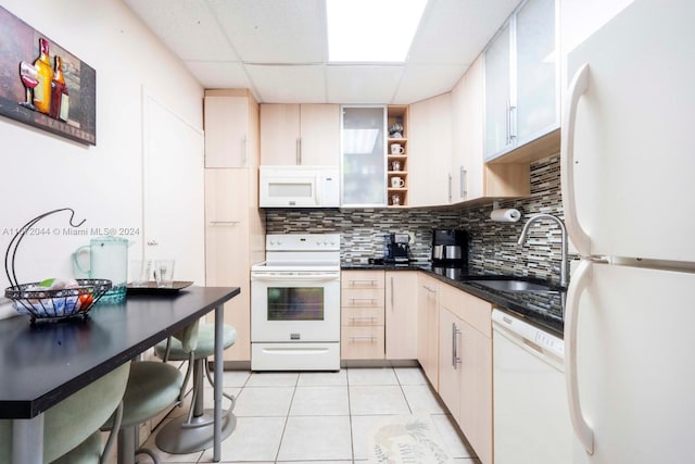 kitchen with decorative backsplash, white appliances, light tile patterned floors, a drop ceiling, and sink