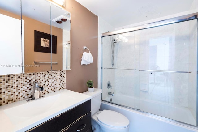 full bathroom with decorative backsplash, bath / shower combo with glass door, vanity, and toilet