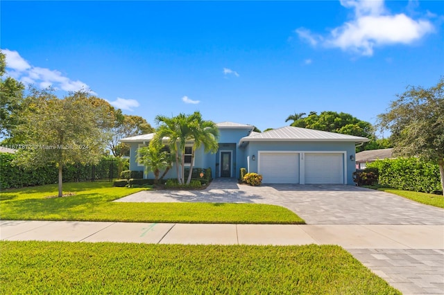 view of front of home with a front yard and a garage