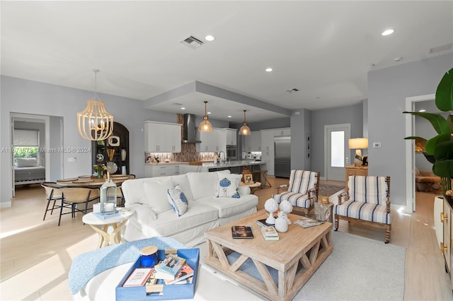 living room with light wood-type flooring and a chandelier