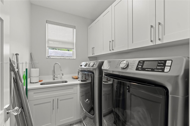 clothes washing area featuring cabinets, sink, and washing machine and clothes dryer