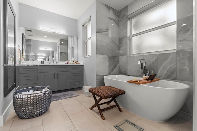 bathroom featuring vanity, a tub, and tile patterned flooring