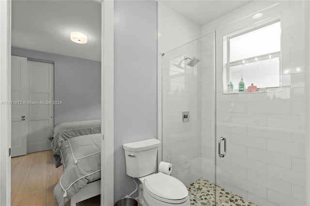 bathroom featuring toilet and an enclosed shower