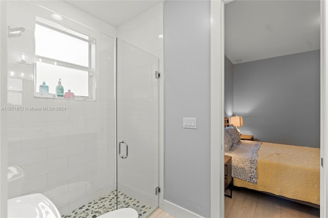 bathroom featuring hardwood / wood-style flooring and a shower with shower door