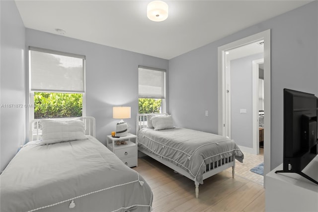 bedroom featuring multiple windows and light wood-type flooring