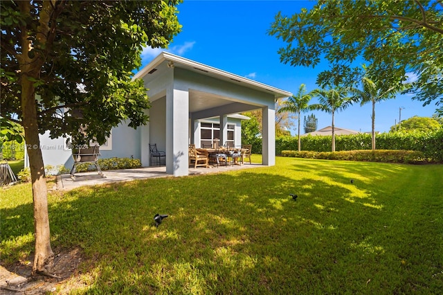 back of house with a patio and a yard