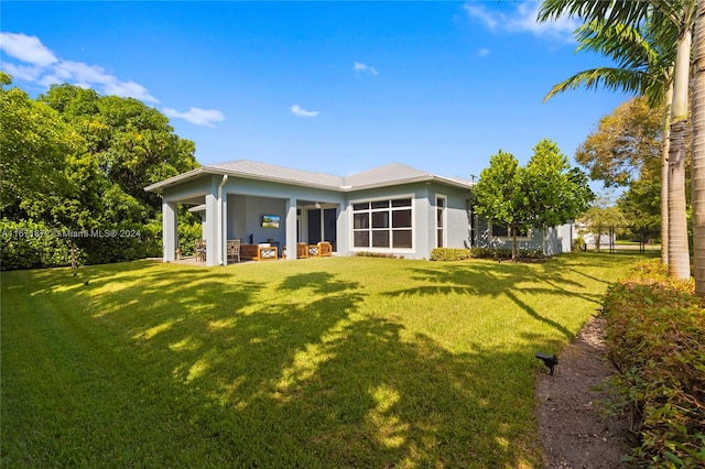 rear view of property featuring a yard