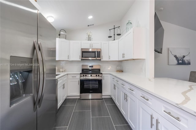 kitchen with white cabinetry, lofted ceiling, decorative backsplash, and stainless steel appliances