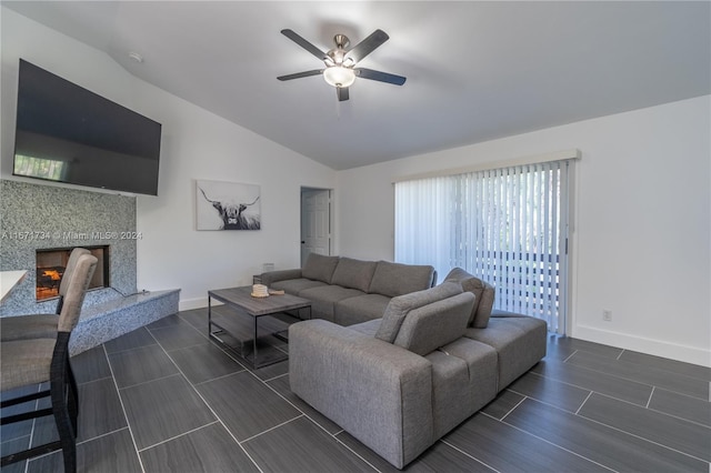 living room with dark wood-type flooring, a premium fireplace, ceiling fan, and lofted ceiling