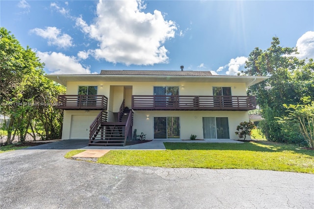 view of front of property with a garage, a front lawn, and a balcony