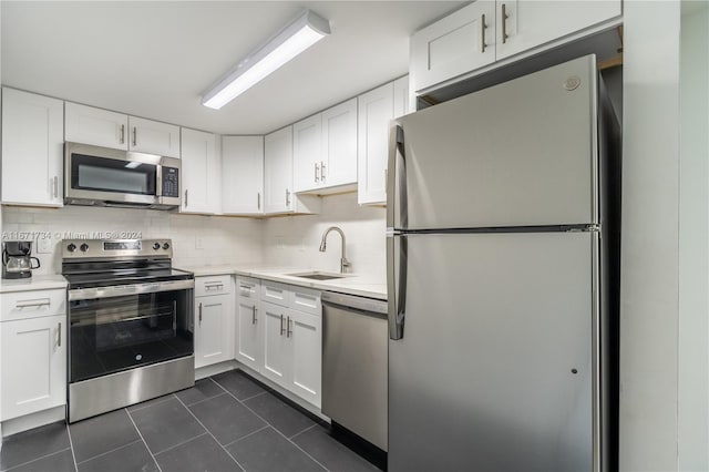 kitchen with white cabinets, decorative backsplash, stainless steel appliances, and sink