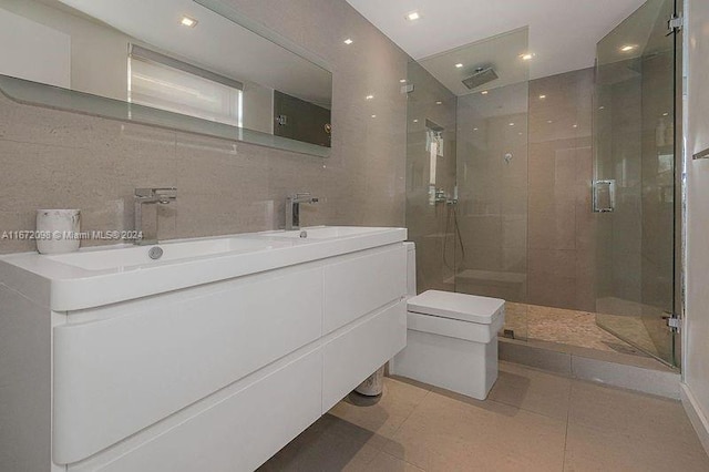 bathroom with vanity, tile patterned floors, a shower with shower door, and backsplash