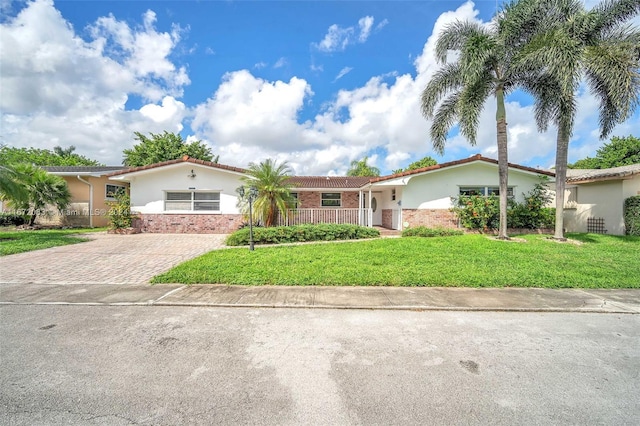 2827 Arthur St, Hollywood, FL 33020 - ranch-style house with stucco siding, a front yard, a tile roof, and brick siding